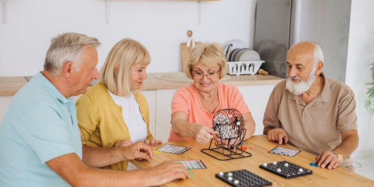 Seniors Playing Bingo Together in Community Room at Assisted Living Facility
